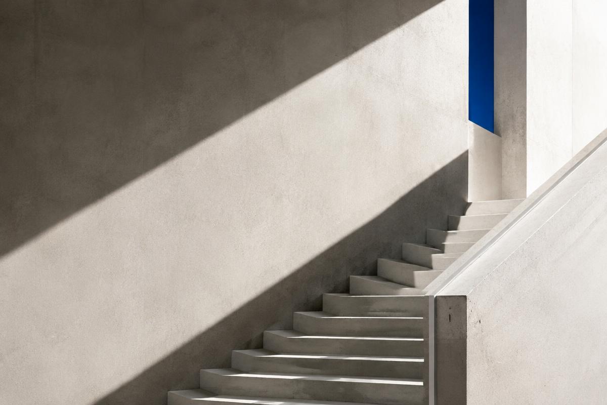 Concrete staircase rising through diagonal light